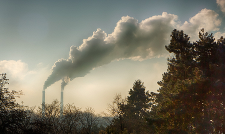 Smoke from industrial chimneys against the blue sky.の写真素材