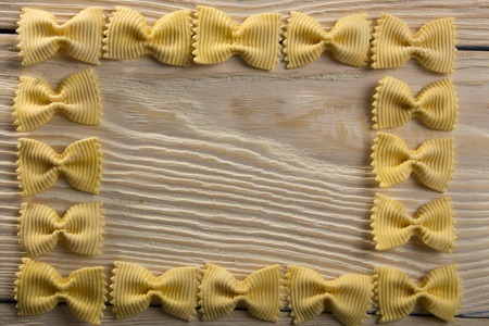 A frame of butterfly pasta on a wooden backgroundの写真素材