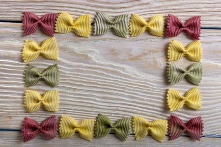 A frame of butterfly pasta on a wooden backgroundの写真素材