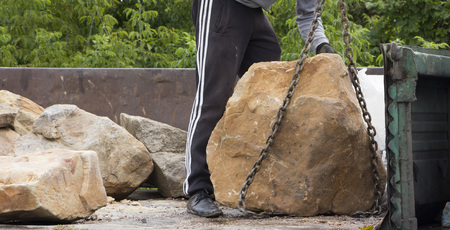 Delivery and unloading of building stone by truck with a craneの写真素材