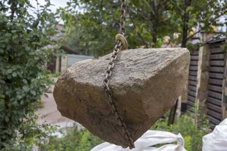 Delivery and unloading of building stone by truck with a craneの写真素材