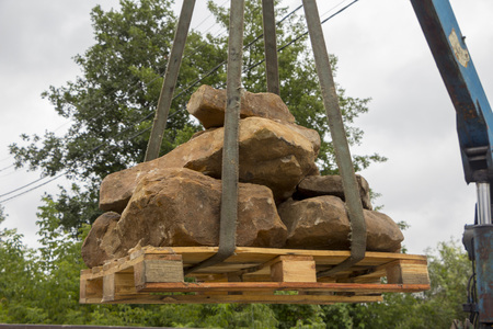 Delivery and unloading of building stone by truck with a craneの写真素材