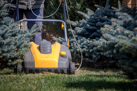 Gardener Operating Soil Aeration Machine on Grass Lawn