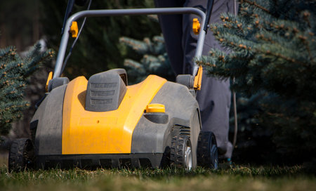 Gardener Operating Soil Aeration Machine on Grass Lawn