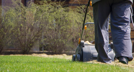 Gardener Operating Soil Aeration Machine on Grass Lawn.