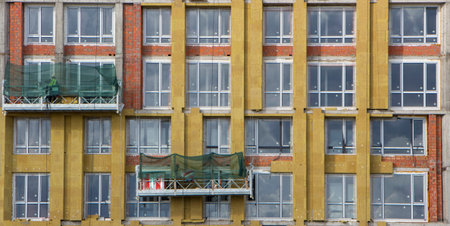 Facade builders warm the walls of a modern high-rise building.