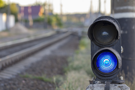 Traffic light on railway tracks. Blue light is on. Close upの写真素材