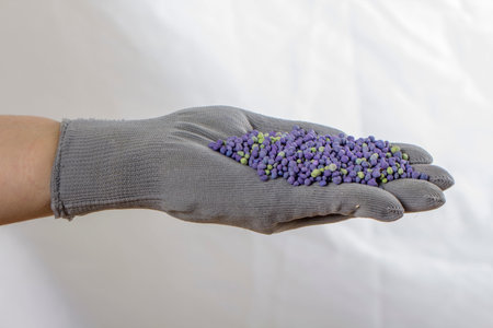 Bun of mineral fertilizer, in the hand on which is put on a mitt.