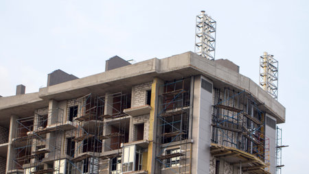 tower crane against the blue sky, the process of building a multi storey building