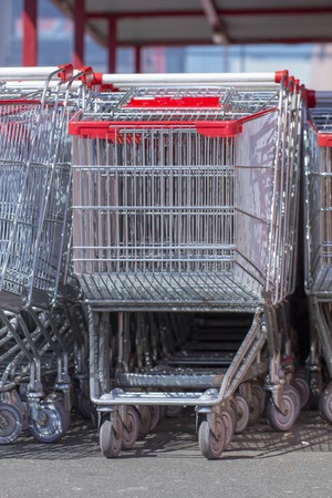Supermarket shopping carts in a row in large supermarket store parking close upの写真素材