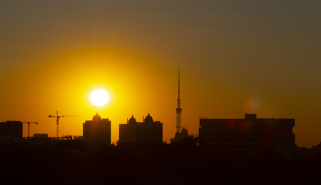 The sunset over the city is a bright orange sky, and lustrous clouds.の写真素材