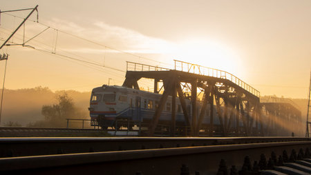 Early in the morning, when the street is foggy, the train is riding on the railway bridge.の写真素材