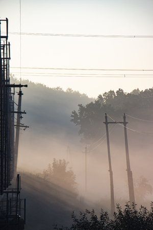 A railway bridge in the morning fog or smoke through which the rays of the sun shine background.の写真素材