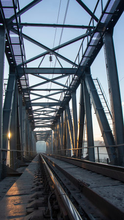 A railway bridge in the morning fog or smoke through which the rays of the sun shine background.