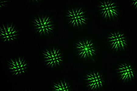 Drawing on a black wall with a green laser. Abstract drawing.の写真素材