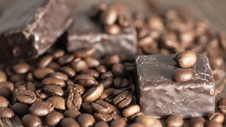Chocolates and coffee seeds on wooden background close upの写真素材