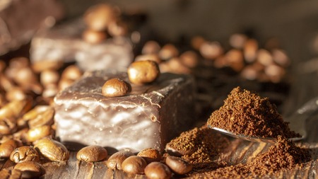 Chocolates and coffee seeds on wooden background close upの写真素材