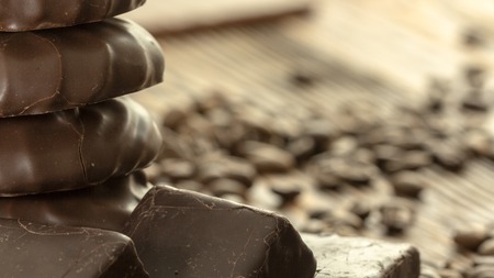 Chocolates and coffee seeds on wooden background close upの写真素材