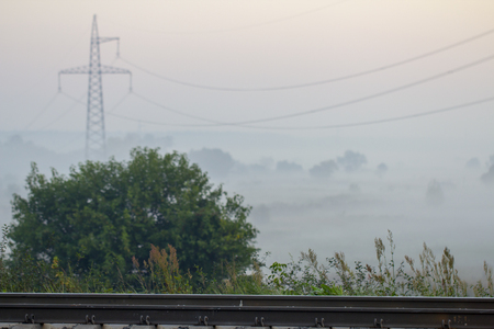 High voltage electricity transfer lines and pylon in a fogの写真素材