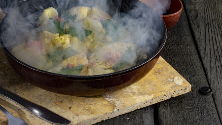 Homemade Fried Potatoes and Omelettes in a Frying Pan. On an old black wooden table close upの写真素材