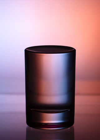 Glass with water on a dark colorful background close upの写真素材