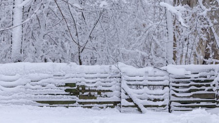 Old wooden snow covered wooden board on a cloudy winter day Backgroundの写真素材