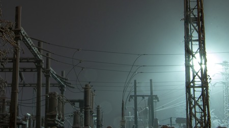 Power transmission towers and their silhouettes against the background of the night sky in the industrial urban area. Illuminated by spotlightsの写真素材
