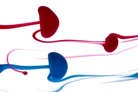 Abstract pattern falling into the water drop of red and blue ink close upの写真素材