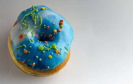 Fresh donut topped with glaze and decorated with colorful decorations on a white background Cose upの写真素材