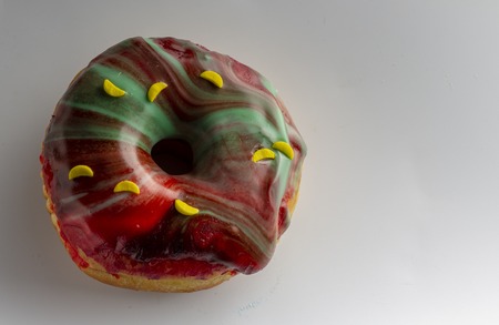 Fresh donut topped with glaze and decorated with colorful decorations on a white background Cose upの写真素材