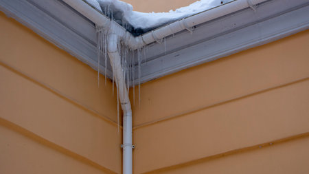 Icicles on the drainpipe and ditch. Incorrect installation of the drainage system, on which large...