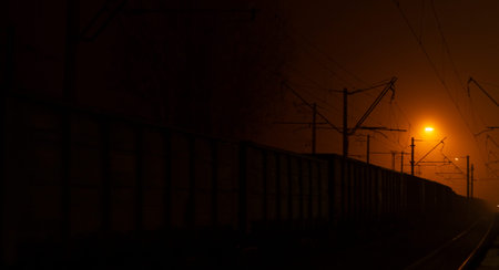 The train arrives at the platform at night. Bright rays of light disperse the darkness. Background