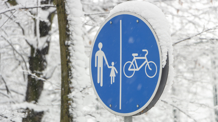 Cyclist pedestrian road sign Located in a snow covered park close upの写真素材