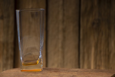 Empty glass cup on a wooden table, with space for writing text,の写真素材