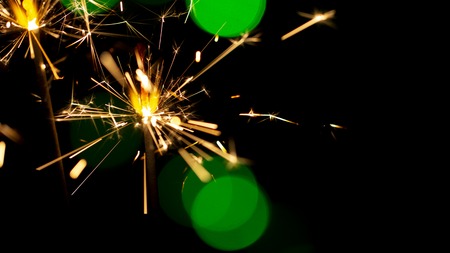 burning sparkler on bokeh background from lights of garland close upの写真素材