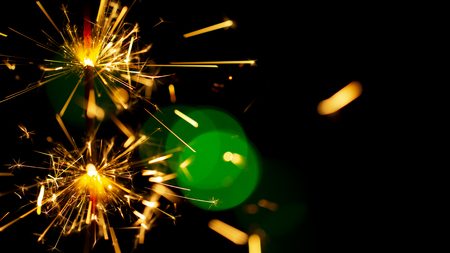 burning sparkler on bokeh background from lights of garland close upの写真素材