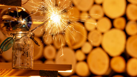 Rustic wooden wall with a sparkler and golden bokeh Christmas concept close up