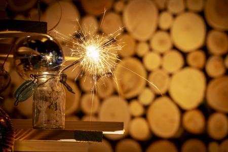 Rustic wooden wall with a sparkler and golden bokeh Christmas concept close upの素材 [FY310114171326]