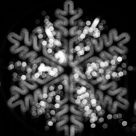 Christmas background, bokeh in the shape of a snowflake, on a black background