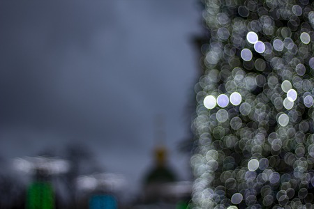 Abstract christmas background with christmas tree with decorations, defocused bokeh lights outdoors.の写真素材