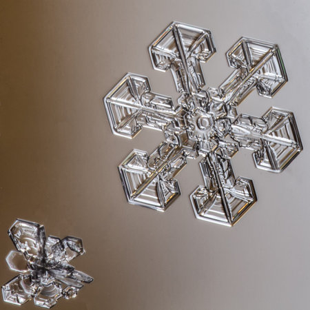Beautiful snow flake on light orange background close-up