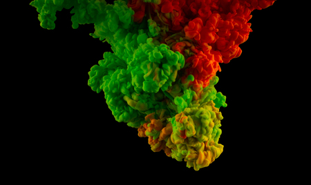 Color splashes of ink isolated on black background. Abstract paint in waterの写真素材