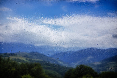 Water droplets on a window pane with beautiful defocused scenery outside. Backgroundの写真素材