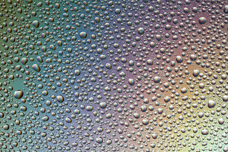 Drops of water on the glass, with the reflection of the rainbow. Backgroundの写真素材