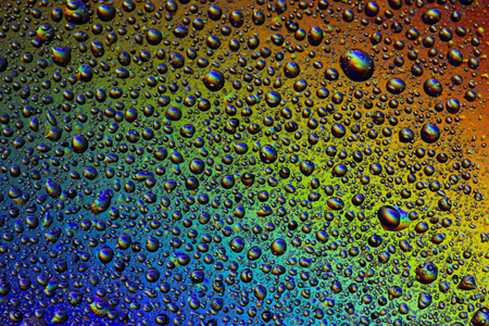 Drops of water on the glass, with the reflection of the rainbow. Backgroundの写真素材