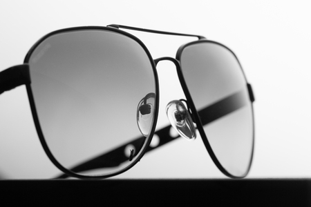 Black polarizing sunglasses in a metal frame on a black fabric background close upの写真素材