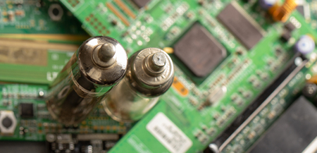 Old vacuum electronic radio tube against the background of the green boardの写真素材