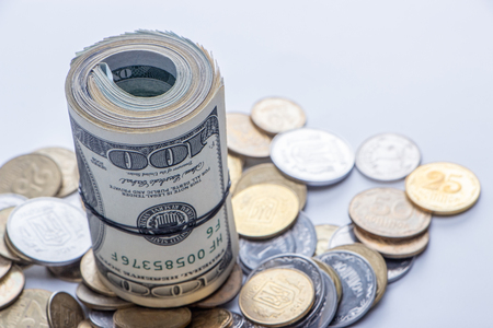 100 dollar bills twisted into tube and tied with an elastic band. white background. Close upの写真素材
