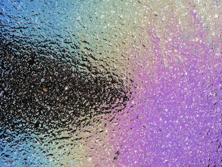 Multi colored oil spill on asphalt road, abstract background, texture.の写真素材