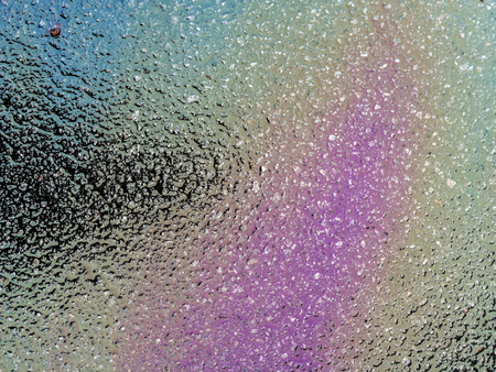 Multi colored oil spill on asphalt road, abstract background, texture.の写真素材